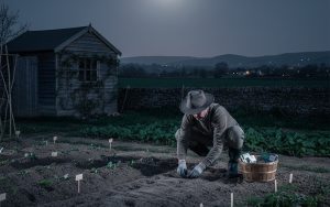 Un jardinier semant des graines sous la lune, illustrant le jardinage selon les cycles lunaires.