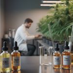 Flacons d'extraits de CBD et THC dans un laboratoire avec des plantes de cannabis.