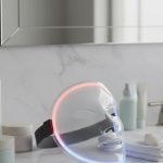Masque LED sur une table de salle de bain avec des produits de soin de la peau.